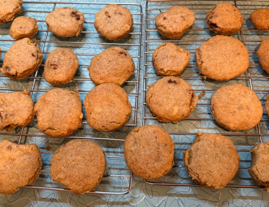 Many yellow banana bread cookies cooling on racks